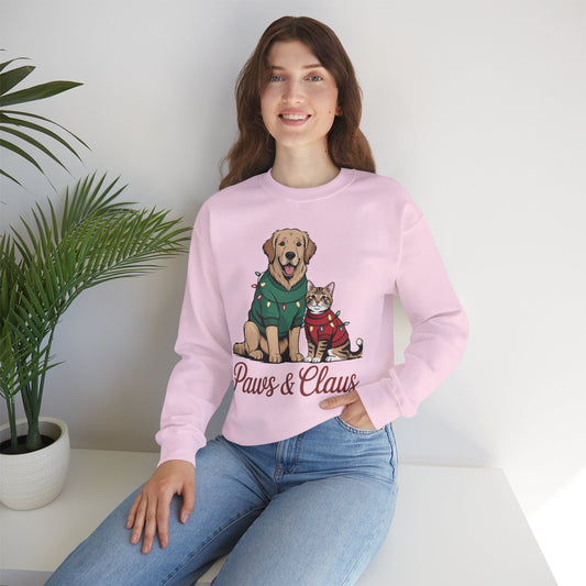 Person wearing a pink sweatshirt with a dog and cat graphic and 'Paws & Claws' text, sitting on a white surface with a plant in the background.